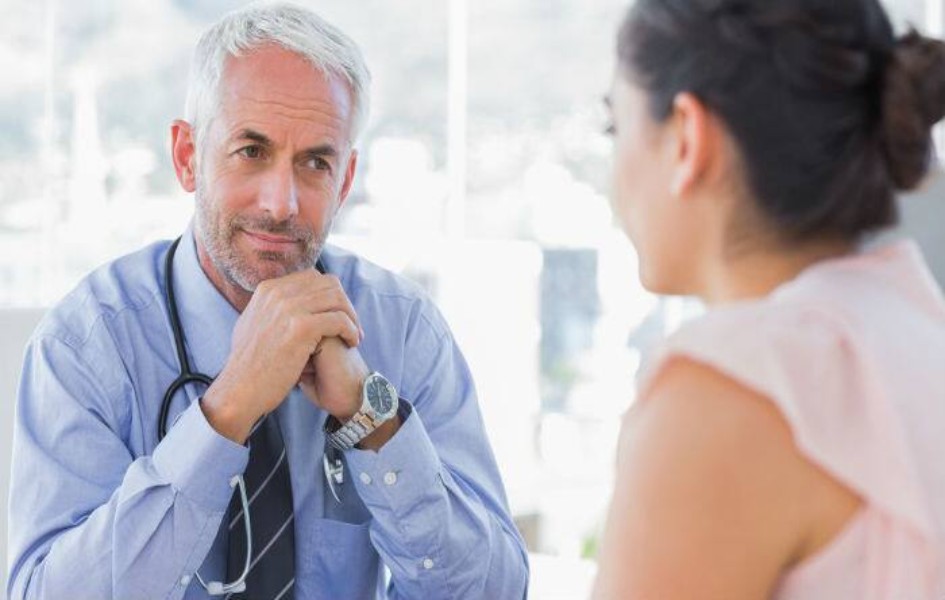 a-healthcare-professional-is-listening-to-a-woman-and-is-seen-wearing-a-stethoscope